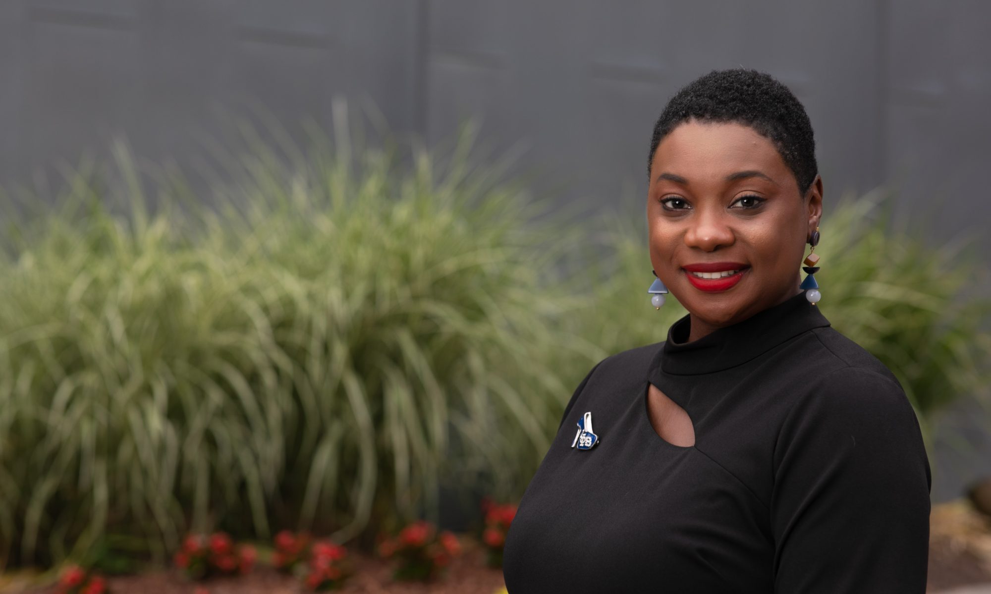 Dr. Treca Bourne positioned in front of a bush