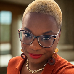 Dr. Treca Bourne in a Burnt Orange Dress