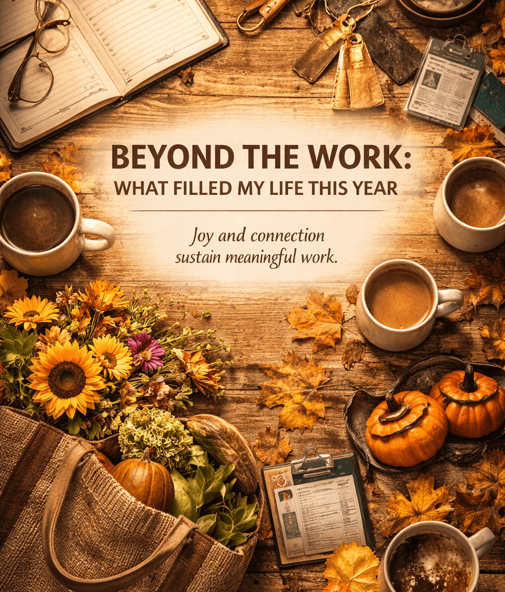 A warm, rustic flat-lay scene on a wooden table featuring objects symbolizing everyday life and personal milestones. At the center, the text reads “BEYOND THE WORK: WHAT FILLED MY LIFE THIS YEAR” with the subheading “Joy and connection sustain meaningful work.” Surrounding the text are fall leaves, mugs of coffee, a bouquet of sunflowers and market flowers, small pumpkins, a canvas market bag filled with produce, an open notebook with glasses, a keyring with hotel-style brass keys, and two work or student ID badges. The color palette blends browns, golds, and oranges, evoking autumn, comfort, and reflection.